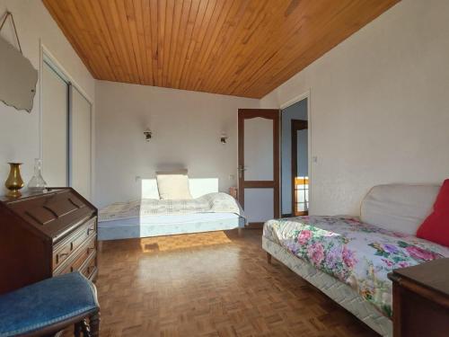 une chambre avec deux lits et un plafond en bois dans l'établissement Maison 3 pièces, à Linxe