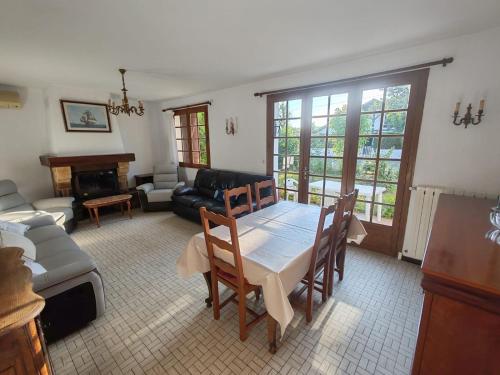 un salon avec une table et un canapé dans l'établissement Maison 3 pièces, à Linxe