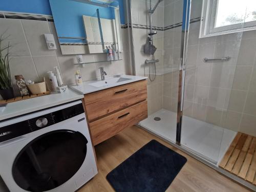 a bathroom with a shower and a washing machine at Ty Mam Goz - Plages à 5 min - wifi - jardin in Concarneau