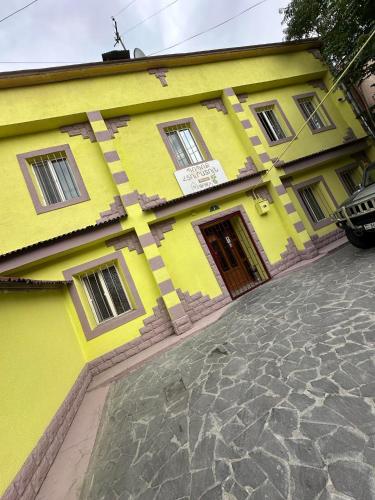 a yellow building sitting on a cobblestone street at Popock City Center in Yerevan