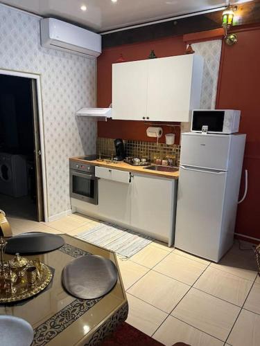 une cuisine avec des appareils blancs et une table dans une pièce dans l'établissement Appartement jaccuzi de L orient, à Arles