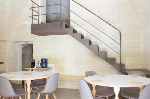 two tables and chairs in a room with a staircase at B&B Kabala in Lecce