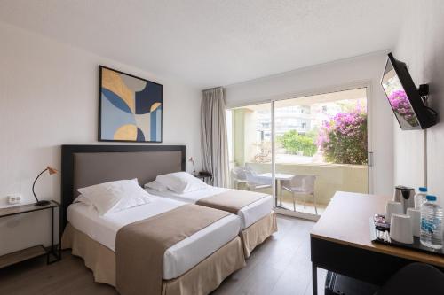a hotel room with two beds and a window at Le Mariana in Calvi