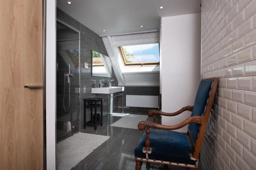 a bathroom with a blue chair and a sink at Villa Ty Castel - Arradon in Ploeren