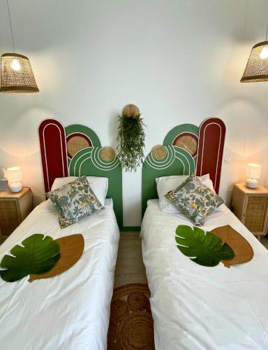 deux lits dans une chambre avec des têtes de lit rouges et vertes dans l'établissement Boudoir - Clim-Wifi-Twin-Gare, à Lourdes