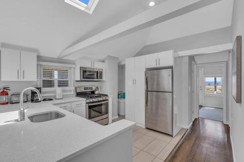Una cocina blanca con fregadero y refrigerador. en Welcome to Manasquan Beach 2 - Steps to the Sand, en Manasquan
