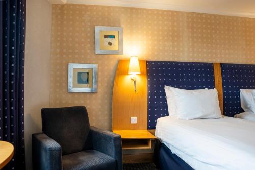 a hotel room with a bed and a chair at The Bolton Stadium Hotel, a member of Radisson Individuals in Bolton