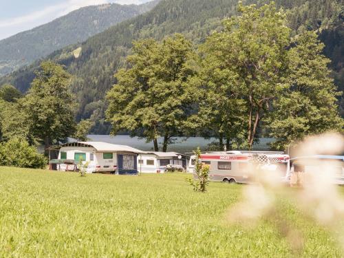 a group of rvs parked in a field at Fischerhof Glinzner Hotel-Restaurant-Camping in Afritz