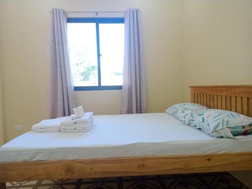 ein Schlafzimmer mit einem Bett mit Handtüchern darauf in der Unterkunft Stockton Inn Siquijor in San Juan
