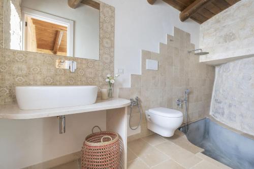 un bagno con lavandino, WC e vasca di Trullo Felicità a Putignano