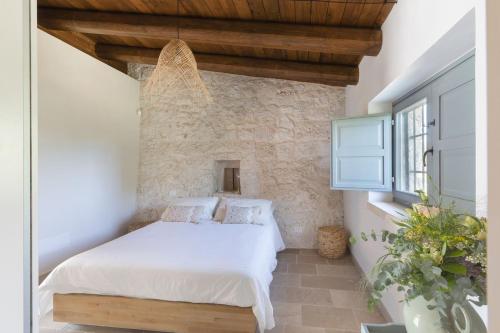 una camera da letto con un letto e un muro di pietra di Trullo Felicità a Putignano