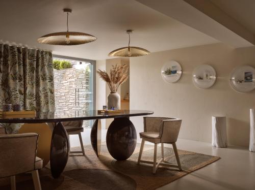 a dining room with a black table and chairs at Eagles Villas - Small Luxury Hotels of The World in Ouranoupoli