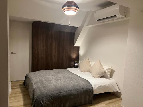 a bedroom with a bed with white sheets and pillows at Ikebukuro Area 41 NishiikeApartment in Tokyo