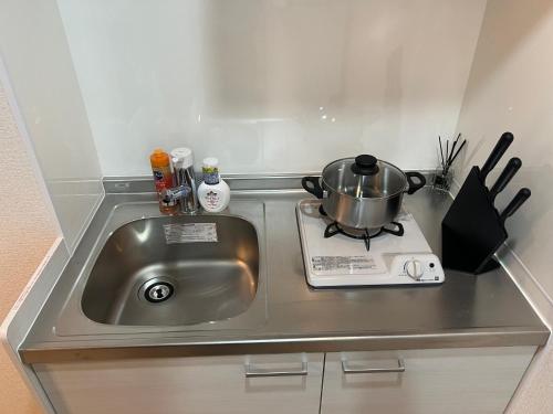 a kitchen sink with a pot on a stove at Ikebukuro Area 41 NishiikeApartment in Tokyo