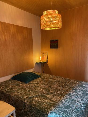 une chambre avec un lit et un lustre dans l'établissement loft charmant dans quartier branché, à Marseille