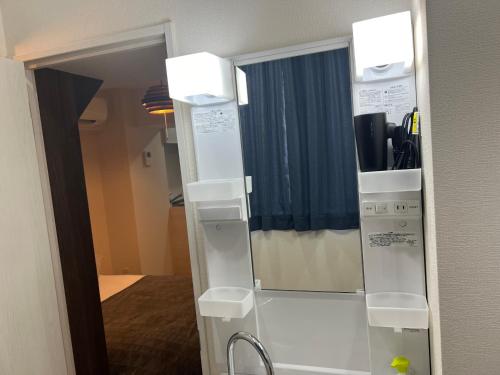 a refrigerator with a mirror in a room at Ikebukuro Area 41 NishiikeApartment in Tokyo
