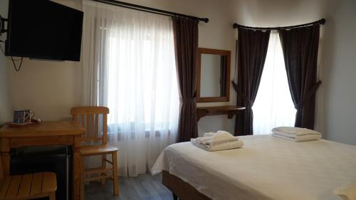a bedroom with a bed and a desk and a window at Pikan Ephesus in Selcuk