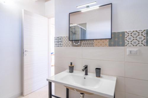 a white bathroom with a sink and a mirror at Agrivillage San Lorenzo in San Lorenzo