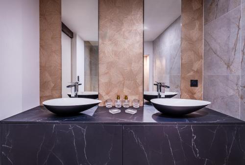 a bathroom with two sinks and two mirrors at Kyriad Chateauroux Nord - Aéroport in Déols