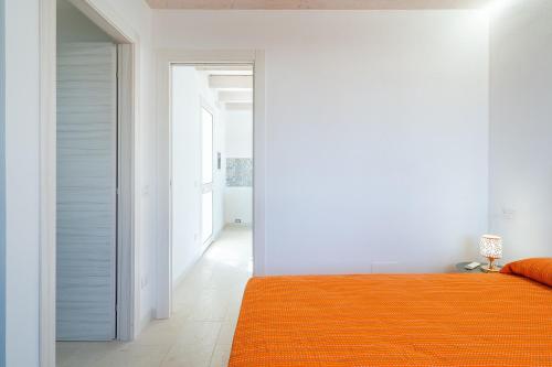 a bedroom with an orange bed and a hallway at Agrivillage San Lorenzo in San Lorenzo