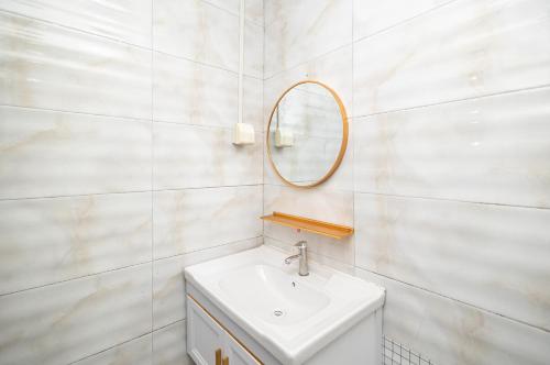 a white bathroom with a sink and a mirror at Changsha Fuxiangyuan International Hostel in Changsha