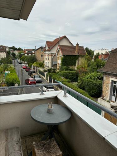 - une table sur un balcon avec vue sur la rue dans l'établissement Studio chambre en mezzanine, à Meudon