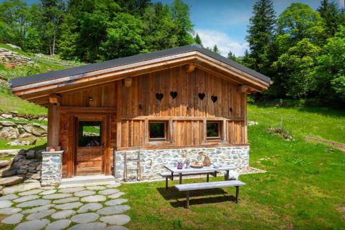 une cabane en rondins avec une table de pique-nique devant elle dans l'établissement Grand Mazot La Chandelle - OVO Network, à Bionnassay