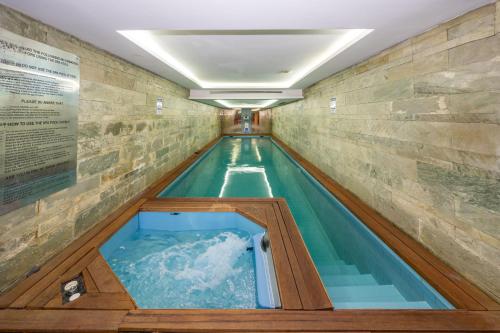 a swimming pool in a building with a water feature at Pera Tulip Hotel & Spa - Istanbul Taksim Pera City Center in Istanbul