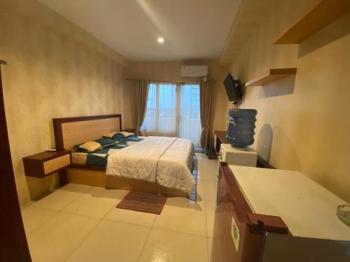 a bedroom with a bed and a television in it at Trieak Skyview Apartment in Sunggal