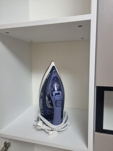 a blue hairdryer sitting on top of a shelf at Somad Apartment in Rediu