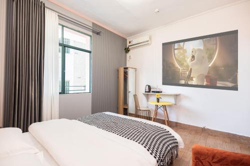 a bedroom with a bed and a tv on the wall at Changsha Fuxiangyuan International Hostel in Changsha