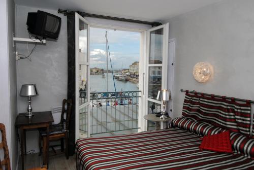 a bedroom with a bed and a view of the water at Les Colonnes in Saint-Martin-de-R&eacute;