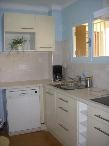 La cuisine est équipée de placards blancs et d'un lave-vaisselle. dans l'établissement Collioure Appartement proche de la mer, à Collioure