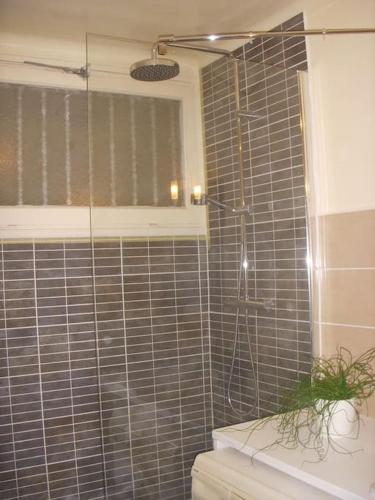 une douche avec une porte vitrée dans une salle de bain dans l'établissement Collioure Appartement proche de la mer, à Collioure