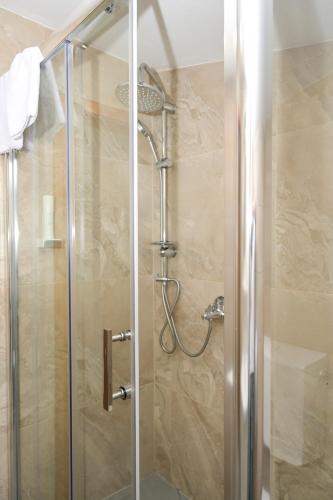 a shower with a glass door in a bathroom at Motel Plaza in Jajce