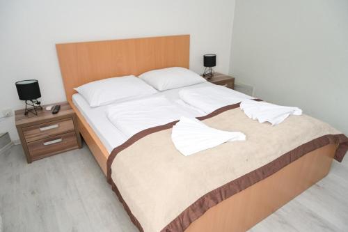 a bedroom with a large bed with a wooden headboard at Motel Plaza in Jajce