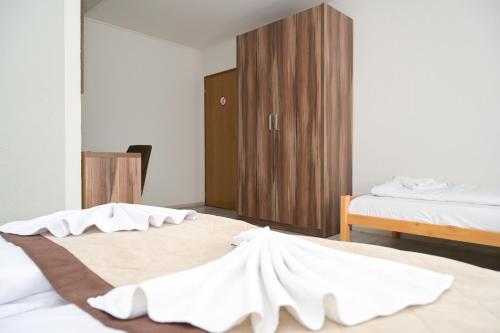 a bedroom with two beds with white sheets at Motel Plaza in Jajce