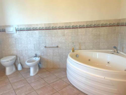 a bathroom with a tub and a toilet and a sink at Sunshine in Sanfatucchio