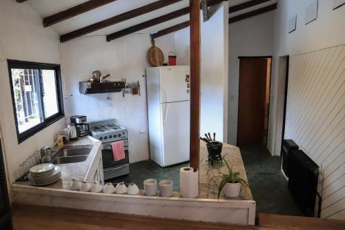 a kitchen with a white refrigerator and some cups at Alto Belgrano Casas Bariloche in San Carlos de Bariloche