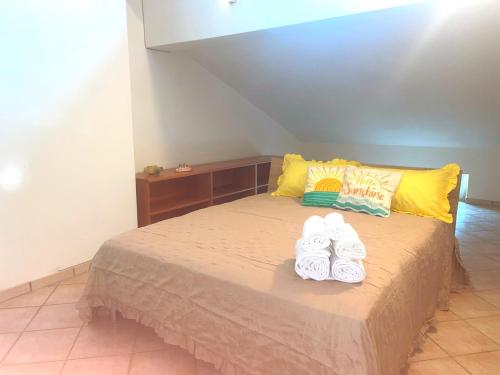 a bed with two pairs of towels on top of it at Sunshine in Sanfatucchio