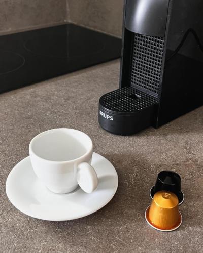 a coffee cup on a plate next to a coffee maker at Alona Luxury Villas in Arkasa