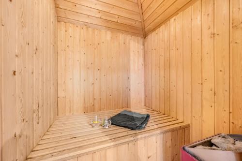 Una sauna de madera con una bolsa negra dentro. en Large Pool House With 6 Person Outdoor Spa 1015, en Ringkøbing