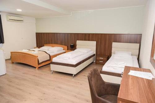 a room with three beds and a table and a chair at Motel Plaza in Jajce