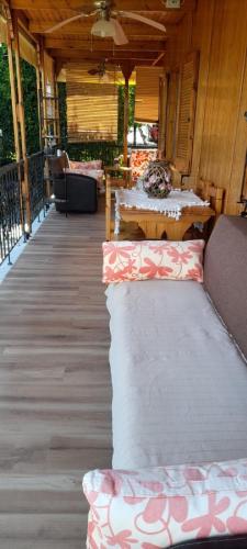 a covered porch with a table and a couch at Anna's Summer House in Nea Kalikratia