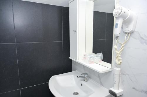 a bathroom with a white sink and a hair dryer at Motel Plaza in Jajce