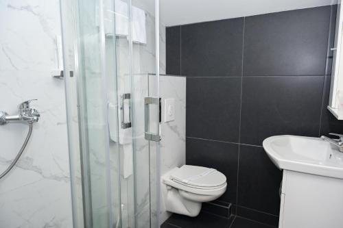 a bathroom with a shower and a toilet and a sink at Motel Plaza in Jajce