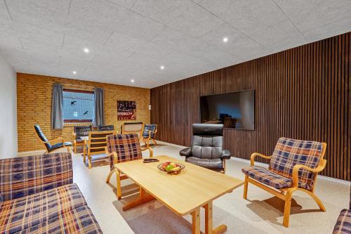 a room with a table and chairs and a television at Large 30-Person Holiday Home With Pool And Spacious Activity Room - 5000 in Engesvang