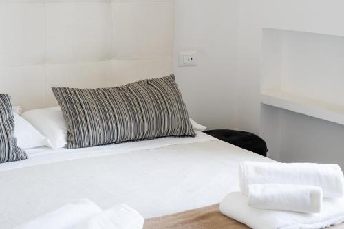a white bed with a pillow on top of it at Villa Angela Suite in Taranto