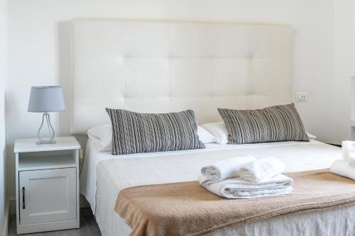 a bedroom with two beds with towels on a table at Villa Angela Suite in Taranto