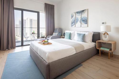 a bedroom with a large bed and a large window at Frank Porter - Aura by Azizi in Dubai